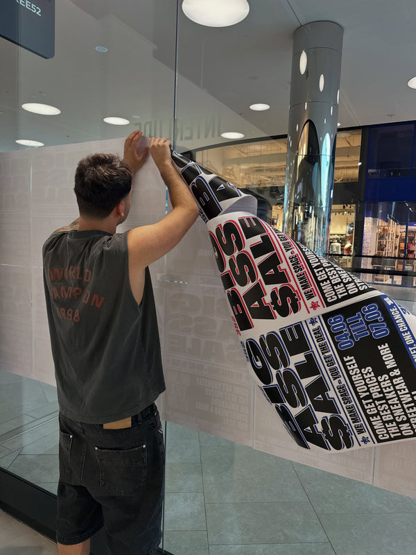 Putting up the Big Ass Sale posters in June